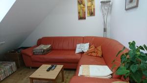- un salon avec un canapé rouge et une table dans l'établissement Ferienwohnung Spatzennest, à Fladungen