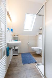 uma casa de banho com um lavatório, um WC e uma janela. em Trailrock Lodge em Dahn