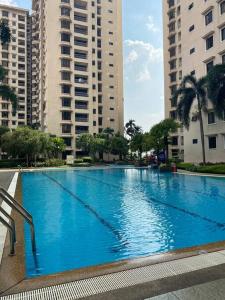 a large blue swimming pool in the middle of buildings at CASA TROPICANA - 2-Room CONDO with facilities in Petaling Jaya