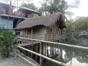 una casa con tetto di paglia sull'acqua di ENCHANTING MAJULI a Majuli