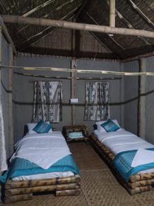 una camera con due letti in un edificio con finestre di ENCHANTING MAJULI a Majuli