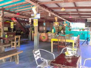 un restaurante con mesas y sillas de madera y una mesa amarilla en Rasta House,,Koh Phayam, en Ko Phayam