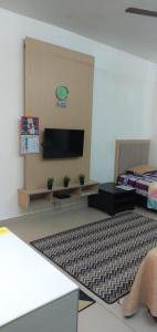 een woonkamer met een flatscreen-tv aan de muur bij NH Studio Apartment Homestay in Wakaf Che Yeh