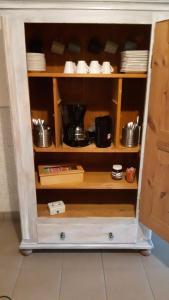 a cupboard with plates and dishes in it at Pension zur Alten Schule in Kirchberg