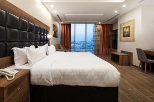 a hotel room with a large bed and a desk at Mirada Purple Zahra - Serviced Apartments in Jeddah +16 photos