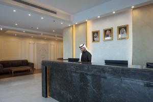 a man standing at a counter in a lobby at Mirada Purple - Zahra in Jeddah