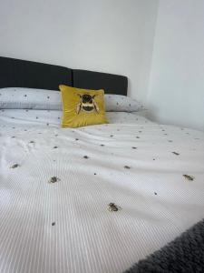 a bed with a yellow pillow with a skull on it at Quiet and central modern new build bungalow in Hereford