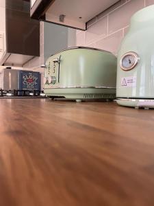 a toaster sitting on top of a wooden floor at Quiet and central modern new build bungalow in Hereford