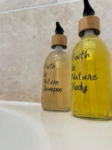 two bottles of yellow liquids sitting on a table at Quiet and central modern new build bungalow in Hereford