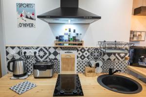 a kitchen with a sink and a stove top oven at Le Petit Aupillon - L'Aupillon des Forêts - 2 studios cocooning aux Orres in Les Orres