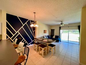 un soggiorno con tavolo e divano di Grand Superior 3BR Townhouse near Disney Parks a Kissimmee