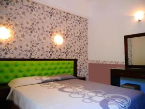 a bedroom with a bed with a green head board at Blue Bay Beach Hotel in Koinyra