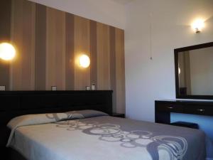 a bedroom with a bed with a dresser and a mirror at Blue Bay Beach Hotel in Koinyra