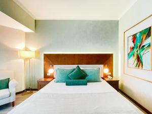 a bedroom with a large bed with blue pillows at Ilica Hotel Spa & Wellness Resort in Çeşme