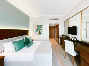 a bedroom with a bed and a desk and a television at Ilica Hotel Spa & Wellness Resort in Çeşme