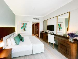 a bedroom with a bed and a desk and a television at Ilica Hotel Spa & Wellness Resort in Çeşme