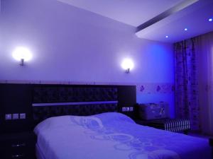 a bedroom with a large bed with purple lighting at Blue Bay Beach Hotel in Koinyra