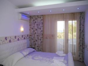 a bedroom with a large white bed and a window at Blue Bay Beach Hotel in Koinyra