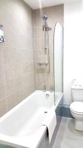 a bathroom with a bath tub and a toilet at Property Hunter 23 in Darlington
