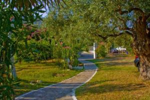a path in a park with trees and flowers at Blue Bay Beach Hotel in Koinyra