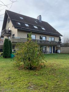a large house with a bush in the yard at Pension Harzkieker in Altenau