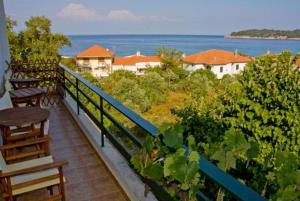 a balcony with benches and a view of the ocean at Blue Bay Beach Hotel in Koinyra