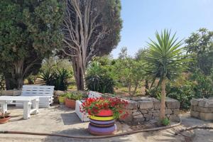 a park with a bench and some plants and trees at Il Casale Apartament&Rooms in Burgio