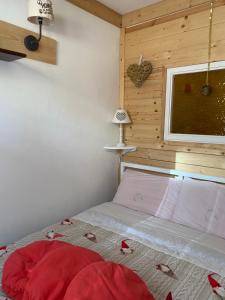 una camera da letto con un letto con un piumone rosso e una finestra di Genziana C2 interno 32 a Prato Nevoso