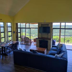 a living room with a blue couch and a fireplace at African Sunset Villa in Chintsa