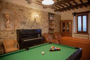 a living room with a pool table and a piano at Maison Vannina in Marsciano