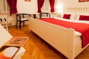 una camera da letto con un grande letto con una coperta rossa di Pivovar Hotel Na Rychtě a Ústí nad Labem