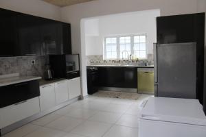 a kitchen with black and white cabinets and appliances at The Rose on Fairway in Durban