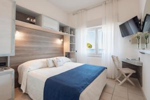 um quarto com uma cama, uma secretária e um computador em Hotel La Caletta em Porto Santo Stefano