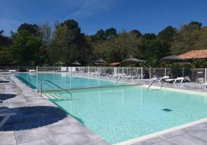 a large swimming pool with chairs and umbrellas at CAMPING Bassin Arcachon - LES GOELANDS in Arès