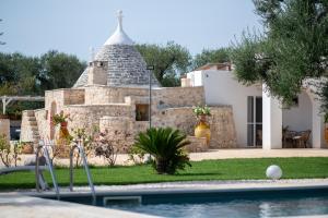 una casa con piscina e un edificio in pietra di Trullo Sunrise - trullo con piscina Privata a San Vito dei Normanni