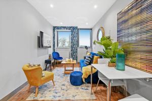 a living room with a blue couch and yellow chairs at Lushh Maidstone Apartments in Kent