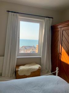 a bedroom with a window with a view of the ocean at 28 North, Stunning Costal home with Generous Ferry Reduction in Ventnor