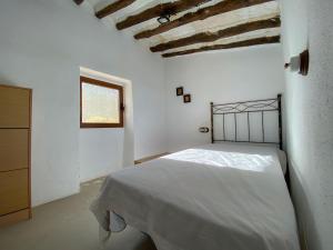 Habitación blanca con cama y ventana en Casa rural La Hidalga, en Sierro