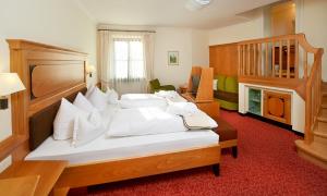 a bedroom with a large bed with white pillows at Hotel zur Post in Bad Koetzting