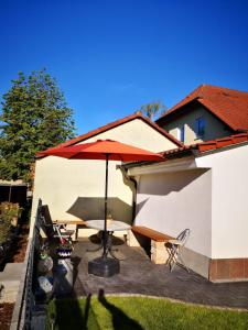a patio with an umbrella and a table and chairs at Pension und Ferienwohnung Walther App. 2 in Storkow