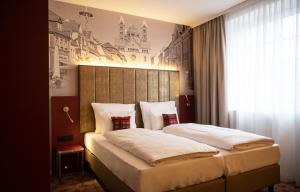 a bedroom with a large bed with a large headboard at Hotel Postgalerie Speyer in Speyer