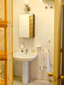 La salle de bains blanche est pourvue d'un lavabo et d'un miroir. dans l'établissement One bedroom apartement with city view balcony and wifi at Sevilla, à Séville