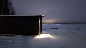 a box sitting in the snow at night at Loma Luonnonlapsi Tuli-mökki in Sotkamo