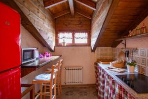 una pequeña cocina con nevera roja y encimera en Sequoia Loft - Family Apartment Lago Maggiore, en Trarego Viggiona