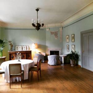 a living room with a table and chairs and a fireplace at Apartment für 4 Personen im Schloss Neuhausen in Berge