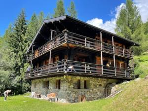 a large building with people sitting on the balcony at Chalet Singlinaz in Zinal
