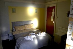a bedroom with a bed with two flowers on it at The Eastleigh in Skegness