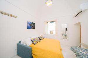 a bedroom with a bed with a yellow blanket at Nonna Titti in Amalfi