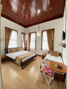 1 dormitorio con 2 camas, mesa y silla en Konak Hotel Kaleiçi en Antalya