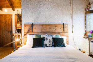 1 dormitorio con cama blanca y cabecero de madera en Sequoia Loft - Family Apartment Lago Maggiore, en Trarego Viggiona